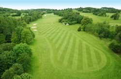 Aerial view of a golf course fairway with sand bunkers and surrounding trees
