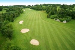 Aerial view of a golf course fairway with sand bunkers and surrounding trees
