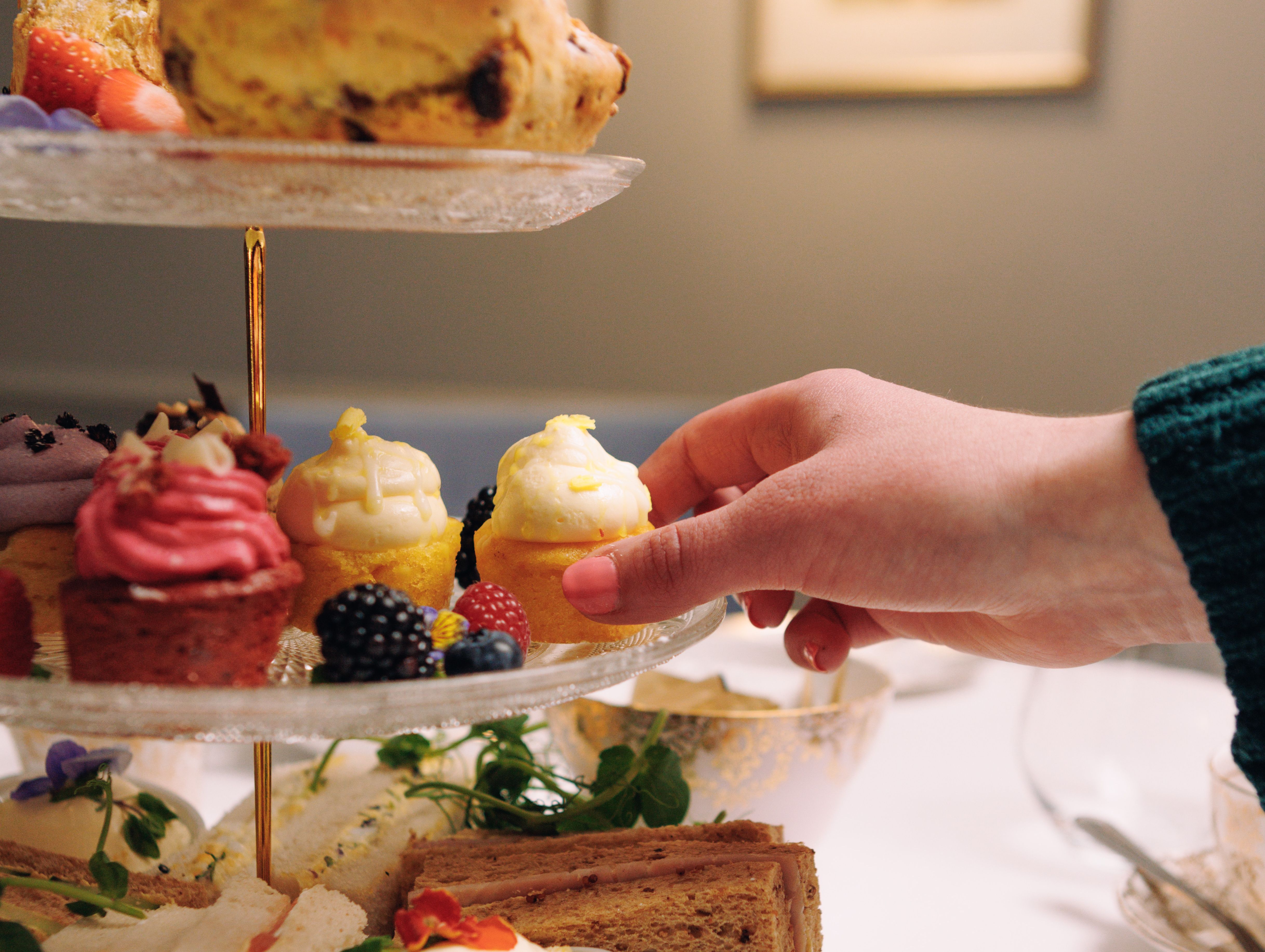 Afternoon Tea with Hand Reaching for Cupcake