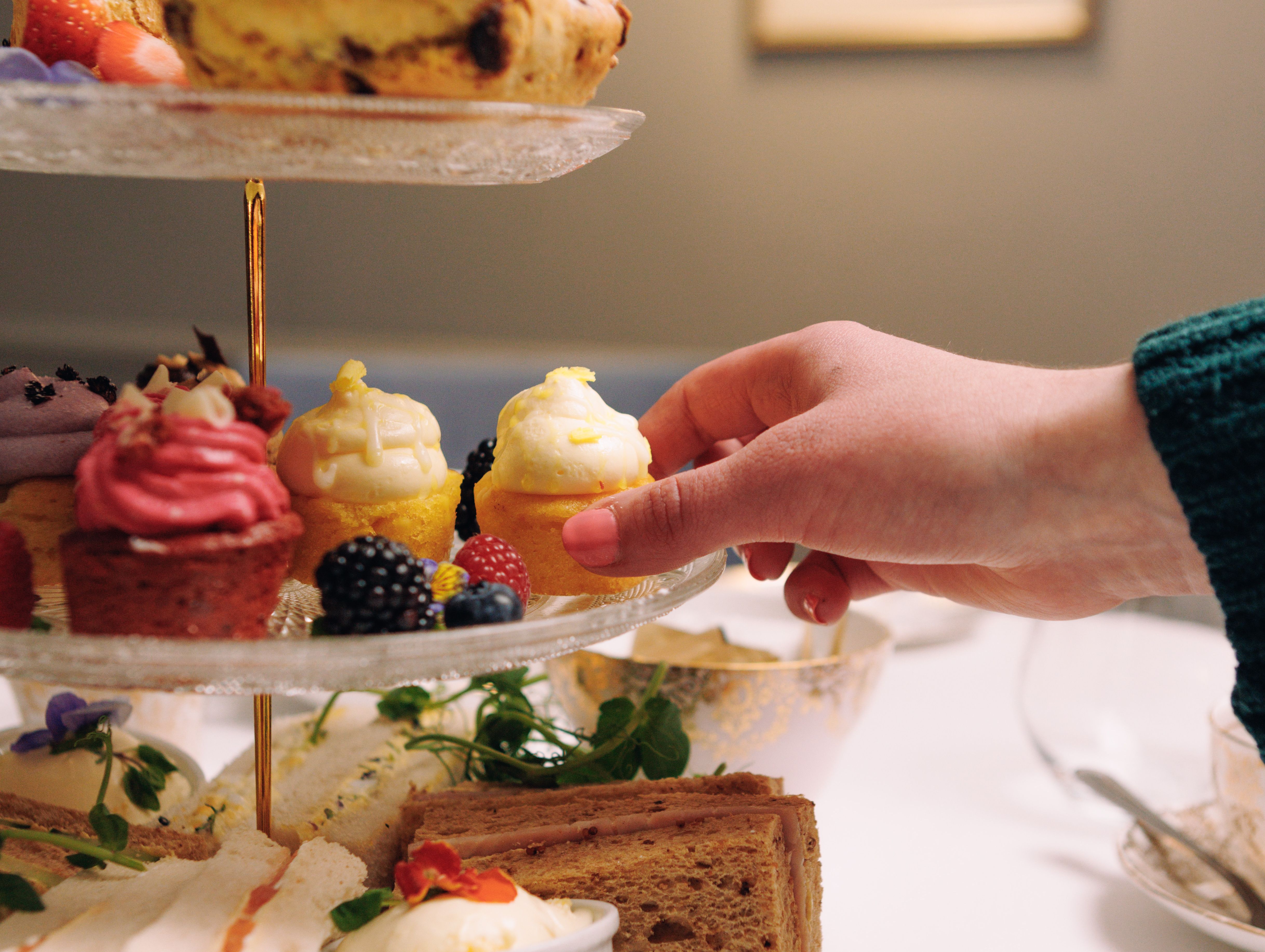 Afternoon Tea with Hand Reaching for Cupcake