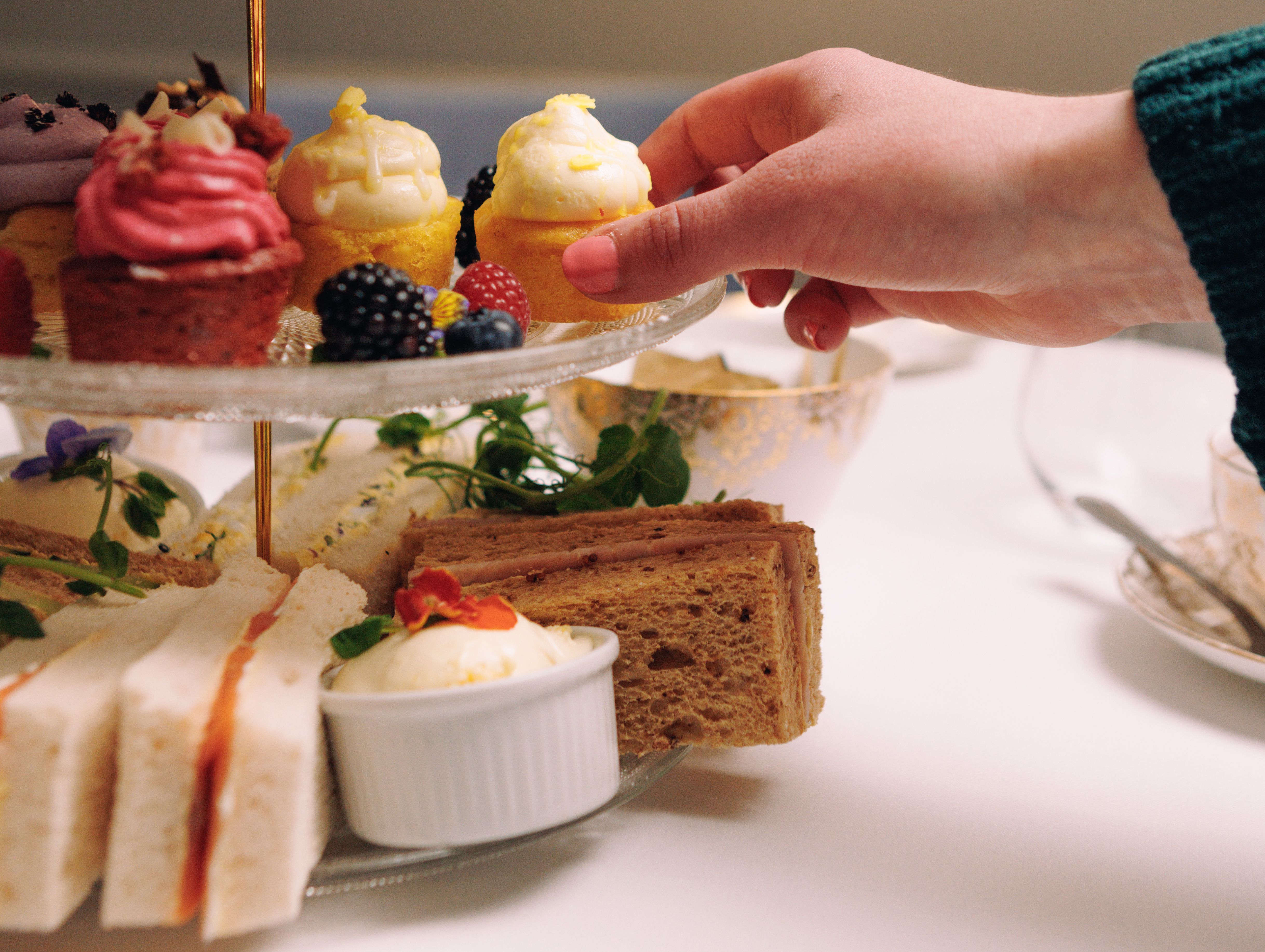 Afternoon Tea with Hand Reaching for Cupcake