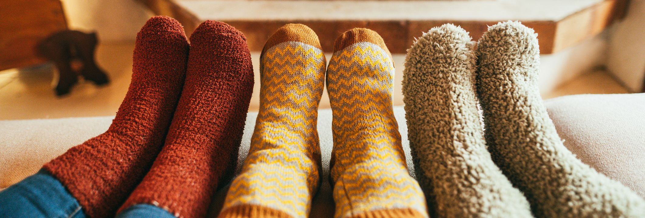 feet with fluffy socks on next to a fir n a autumn day
