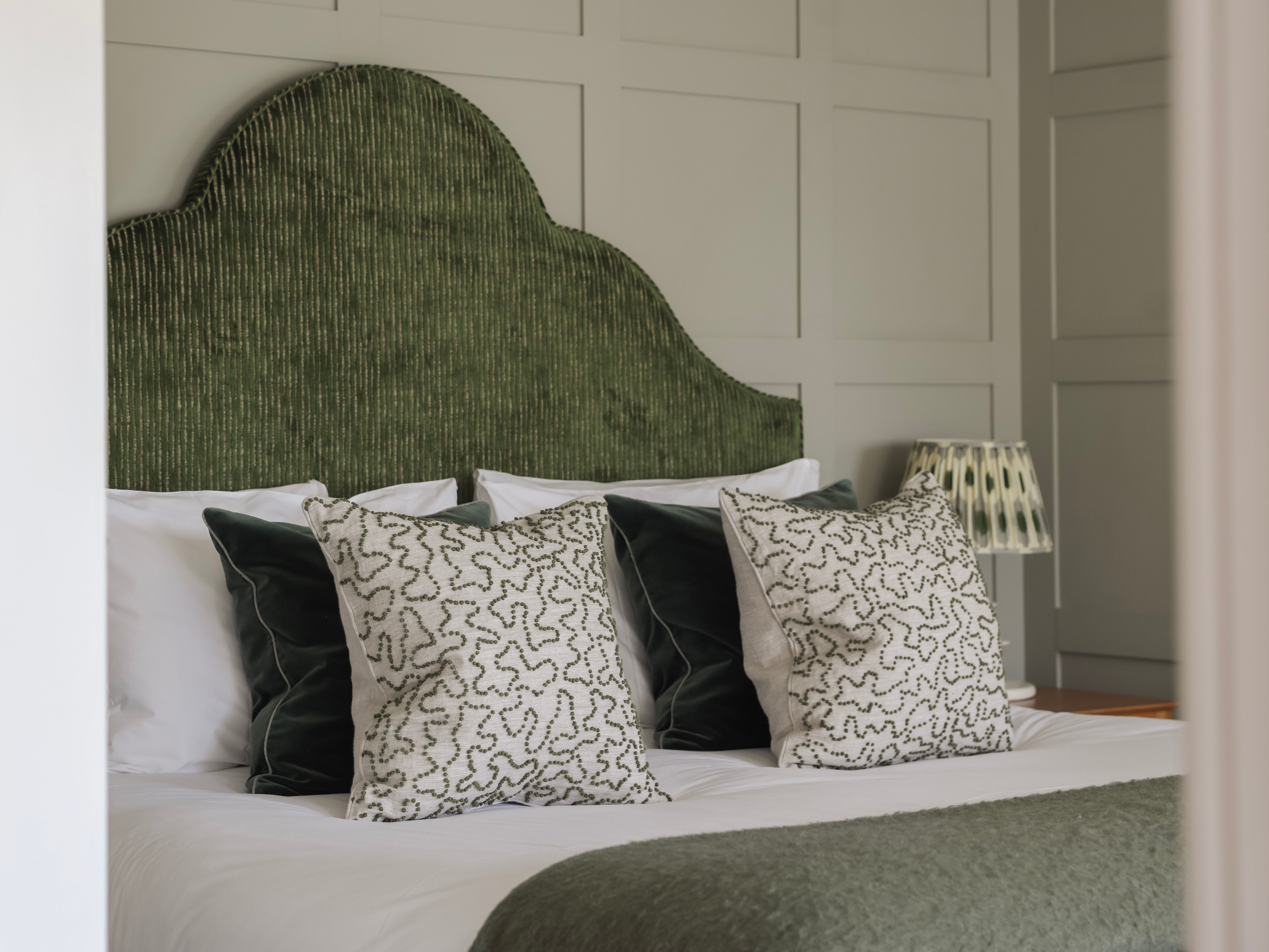 Stylish bedroom with a green textured headboard and decorative pillows