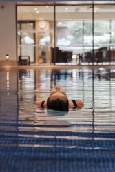 Person floating on their back in an indoor swimming pool