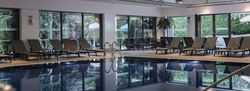 Indoor swimming pool area with lounge chairs and large windows