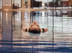 Person floating on their back in an indoor swimming pool