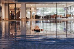 Person floating on their back in an indoor swimming pool