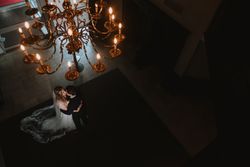Bride and groom sharing a romantic moment under a chandelier