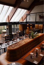 Modern restaurant interior with large windows, stylish seating, and decorative wine corks.