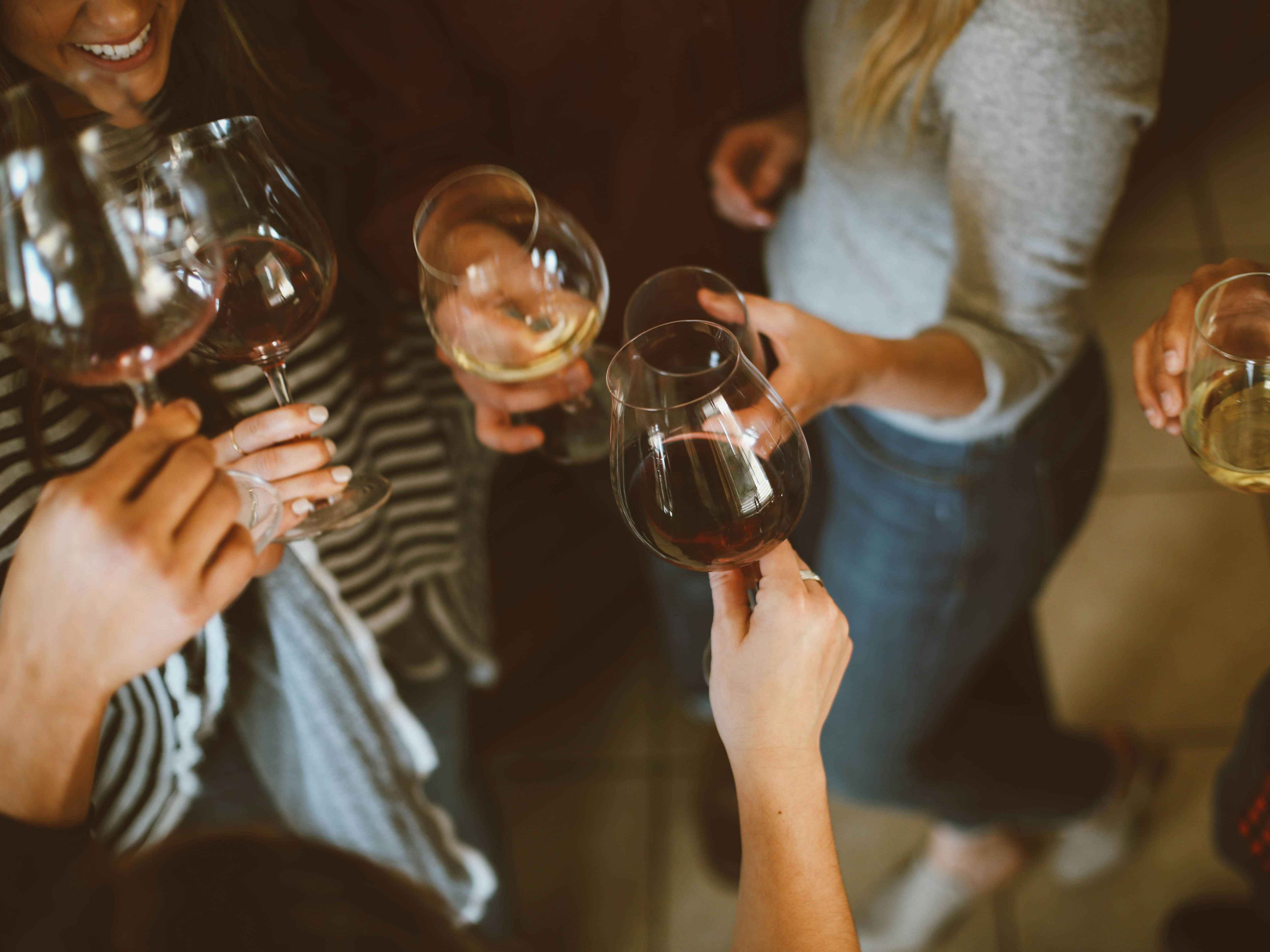 People holding glasses of wine and toasting together