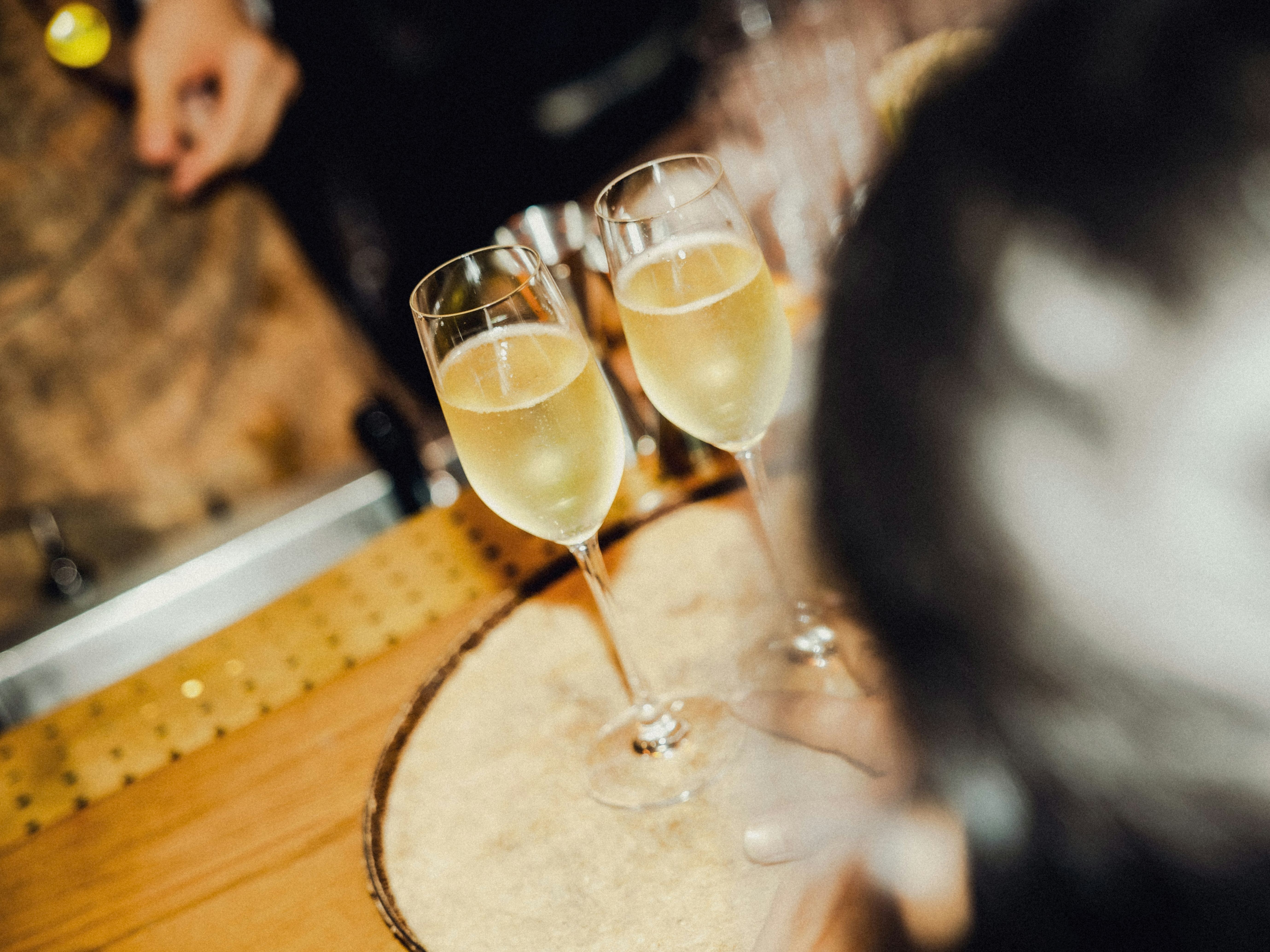 Two glasses of champagne on a wooden bar table