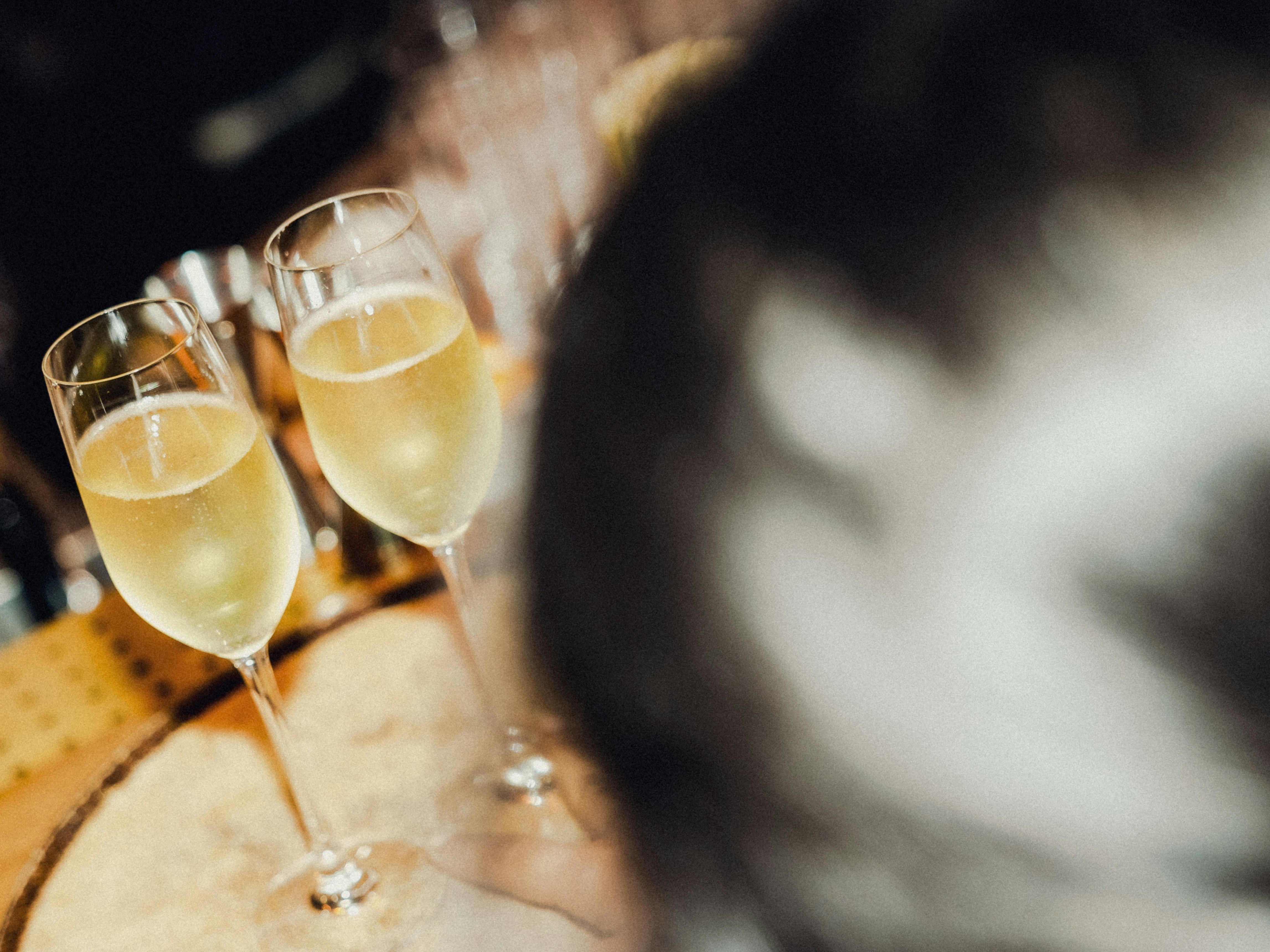 Two glasses of champagne on a wooden bar table