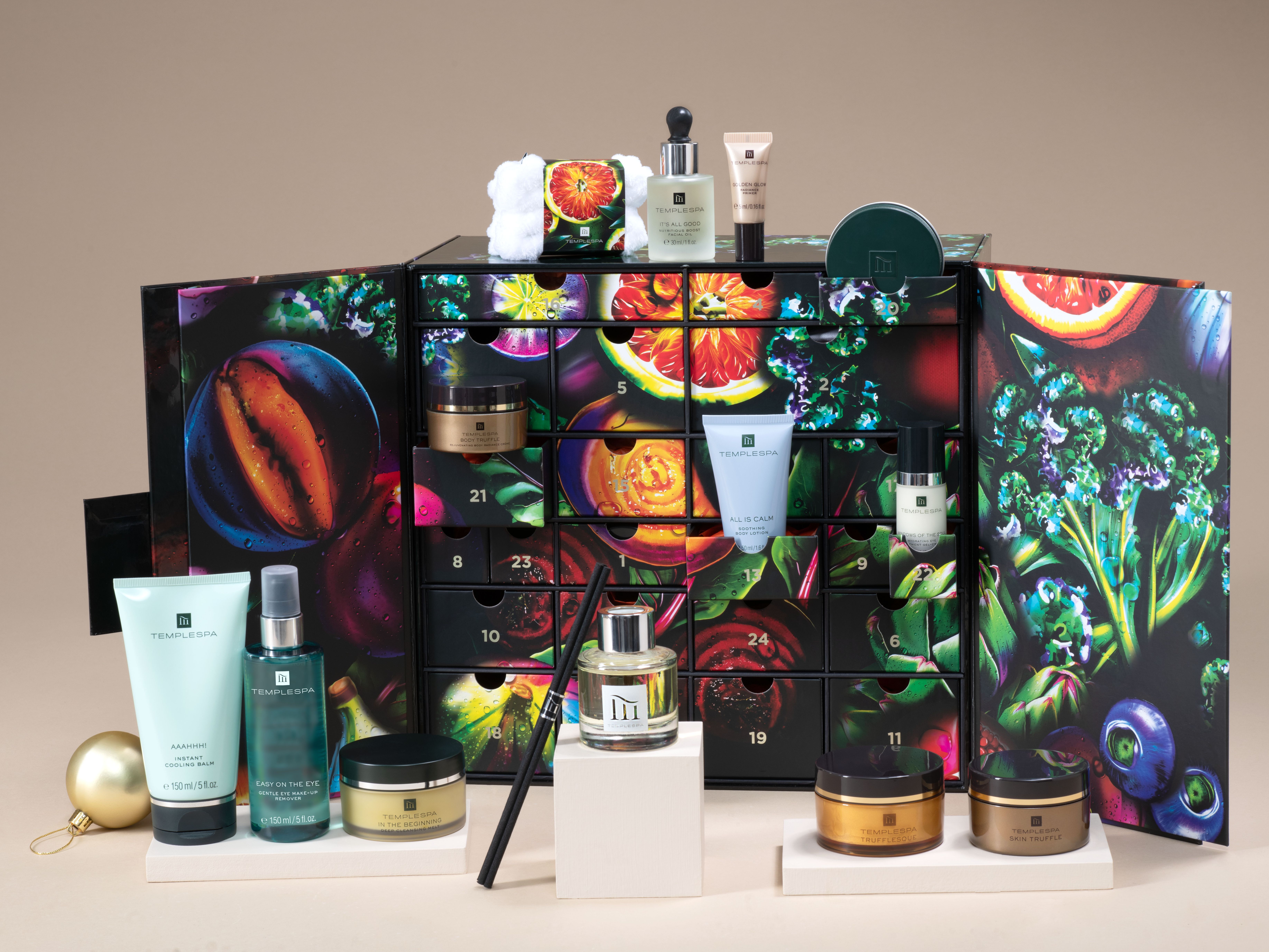 Temple Spa advent calendar with various skincare products arranged in front and inside the decorative calendar box