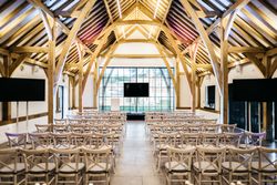 Modern conference room with rows of chairs and wooden beam ceiling