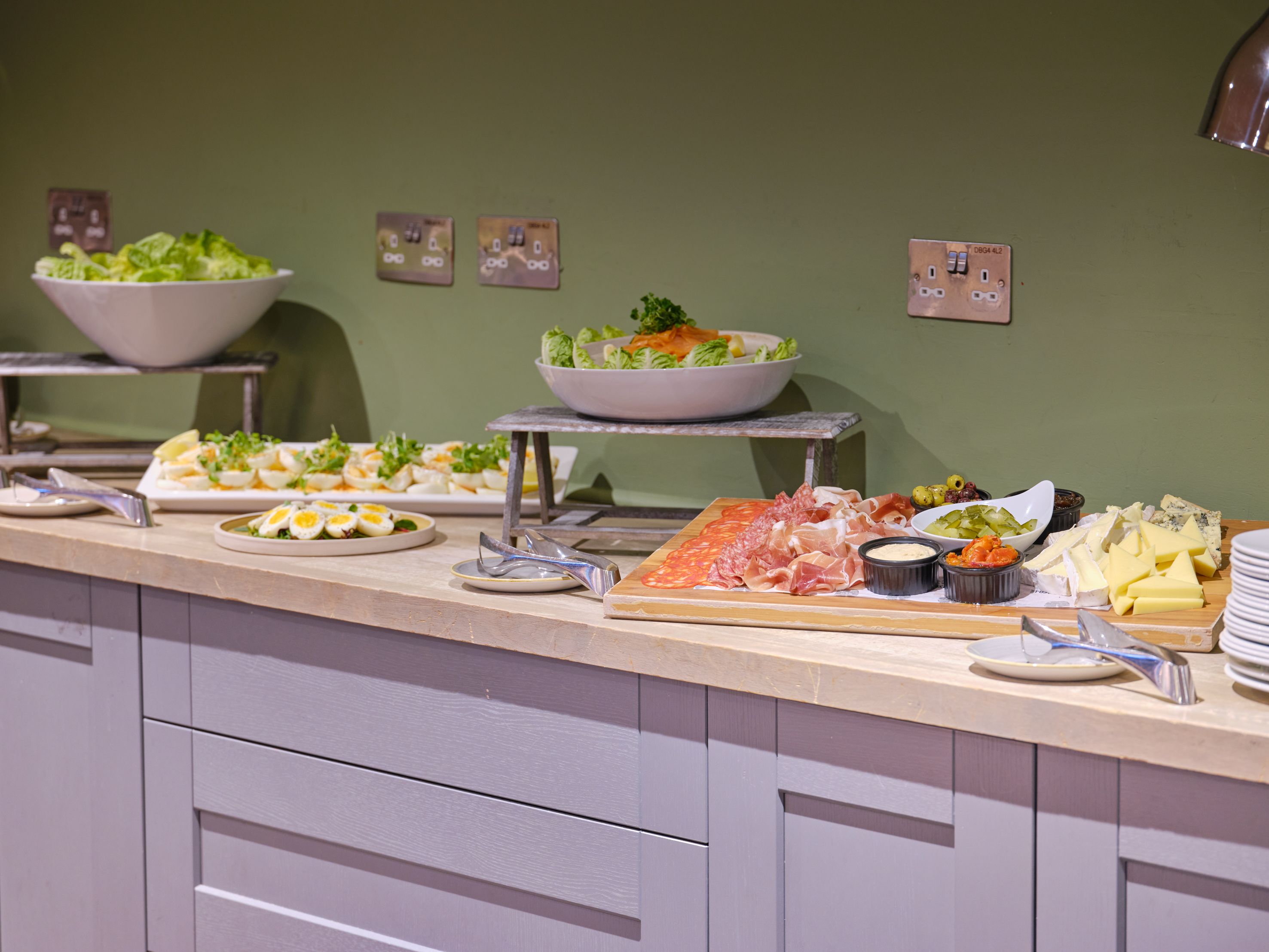 Buffet table with salad, deviled eggs, cold cuts, cheeses, and dips