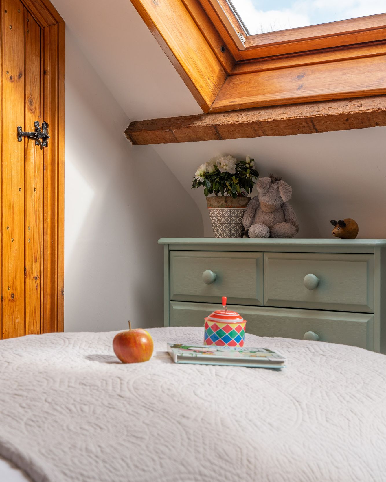 Kids toy, apple and book on bed