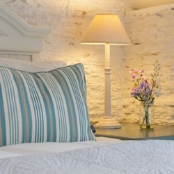 Detail photo of the bed in the dairy with small vase of flowers