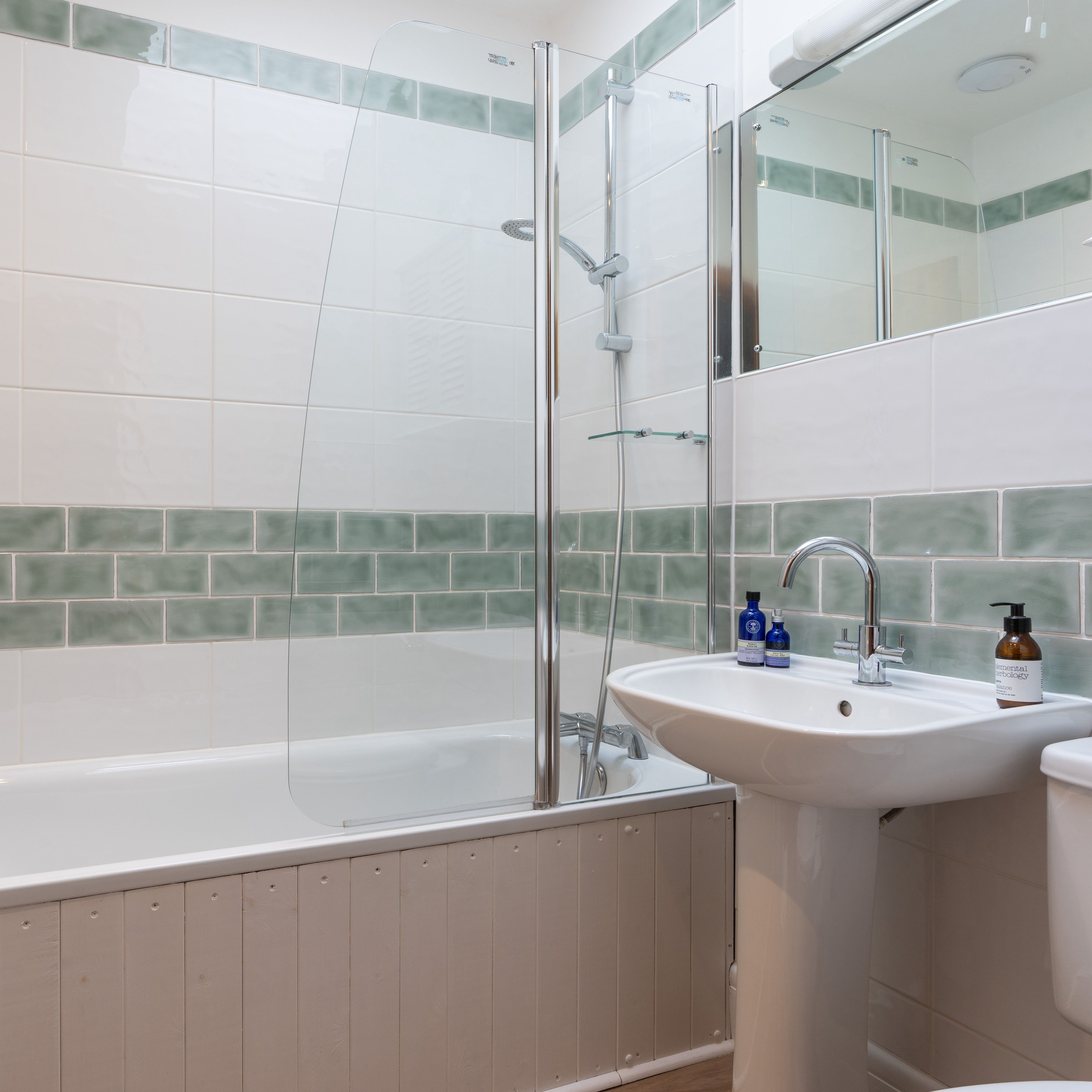 Bathroom with bath and shower over the top