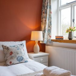 Stables main bedroom with terracotta colour feature wall