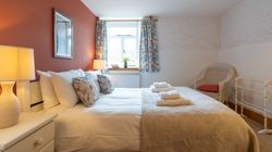 Stables main bedroom with terracotta colour feature wall