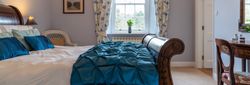 Overall room with traditional bed and blue cover