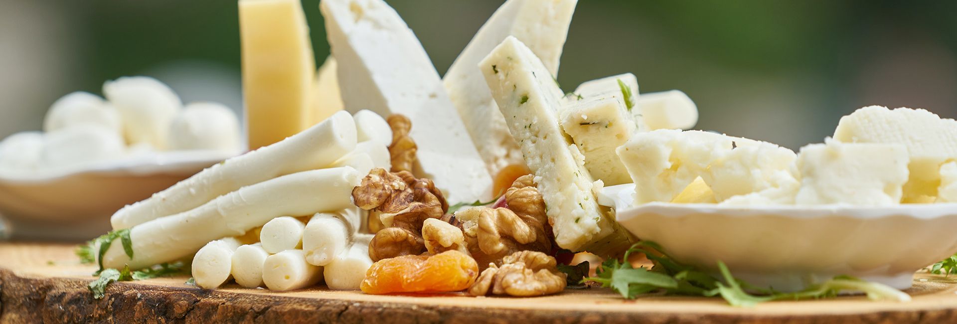 Assorted cheeses with walnuts and dried apricot on a wooden board