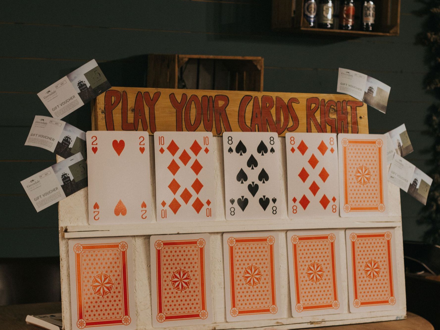 greendale kitchen quiz play your cards right game showing two layers of playing cards and a sign reading Play Your Cards Right above