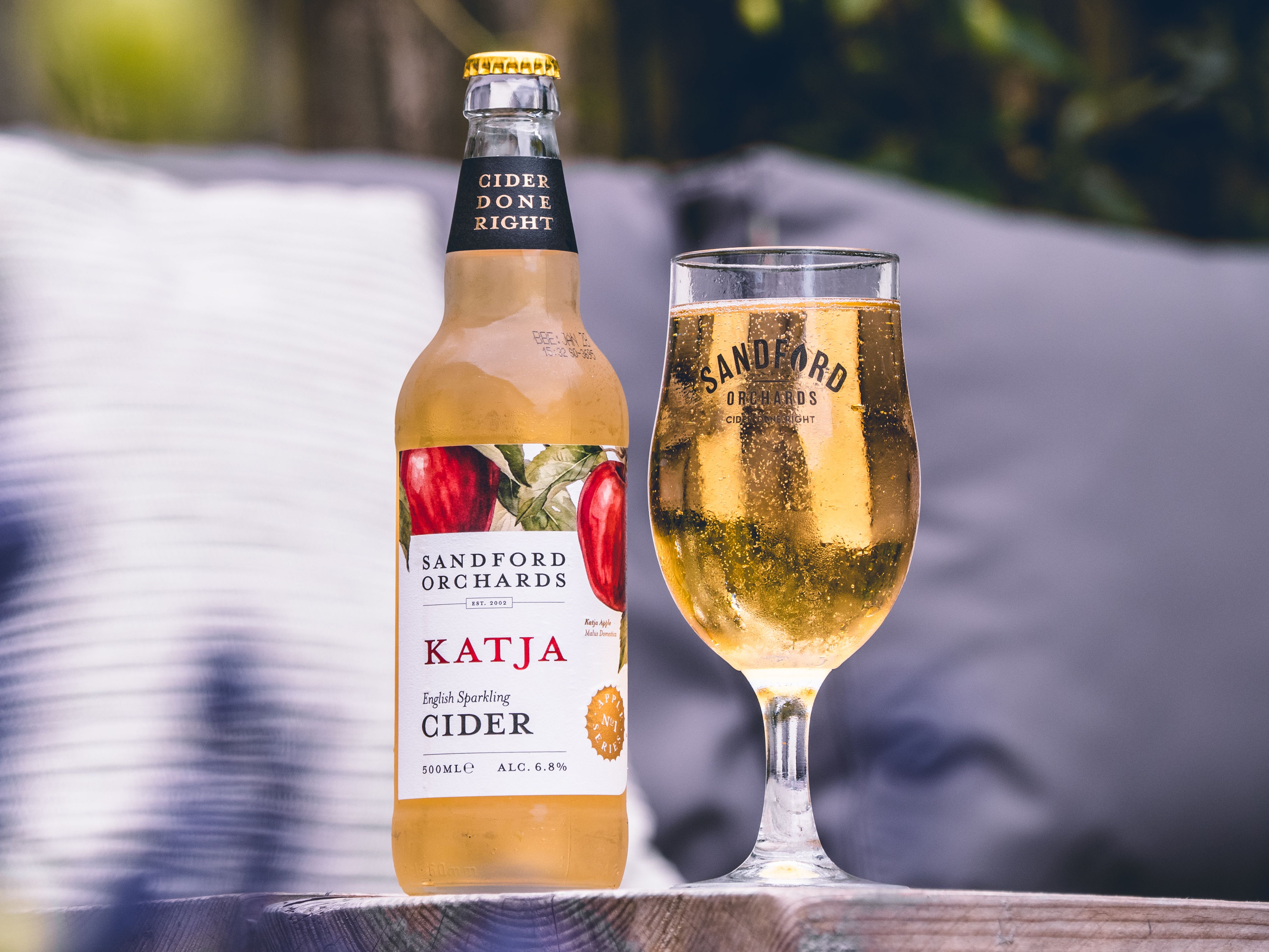 Sandford Orchards Katja sparkling cider - a 500ml bottle next to a glass full of cider