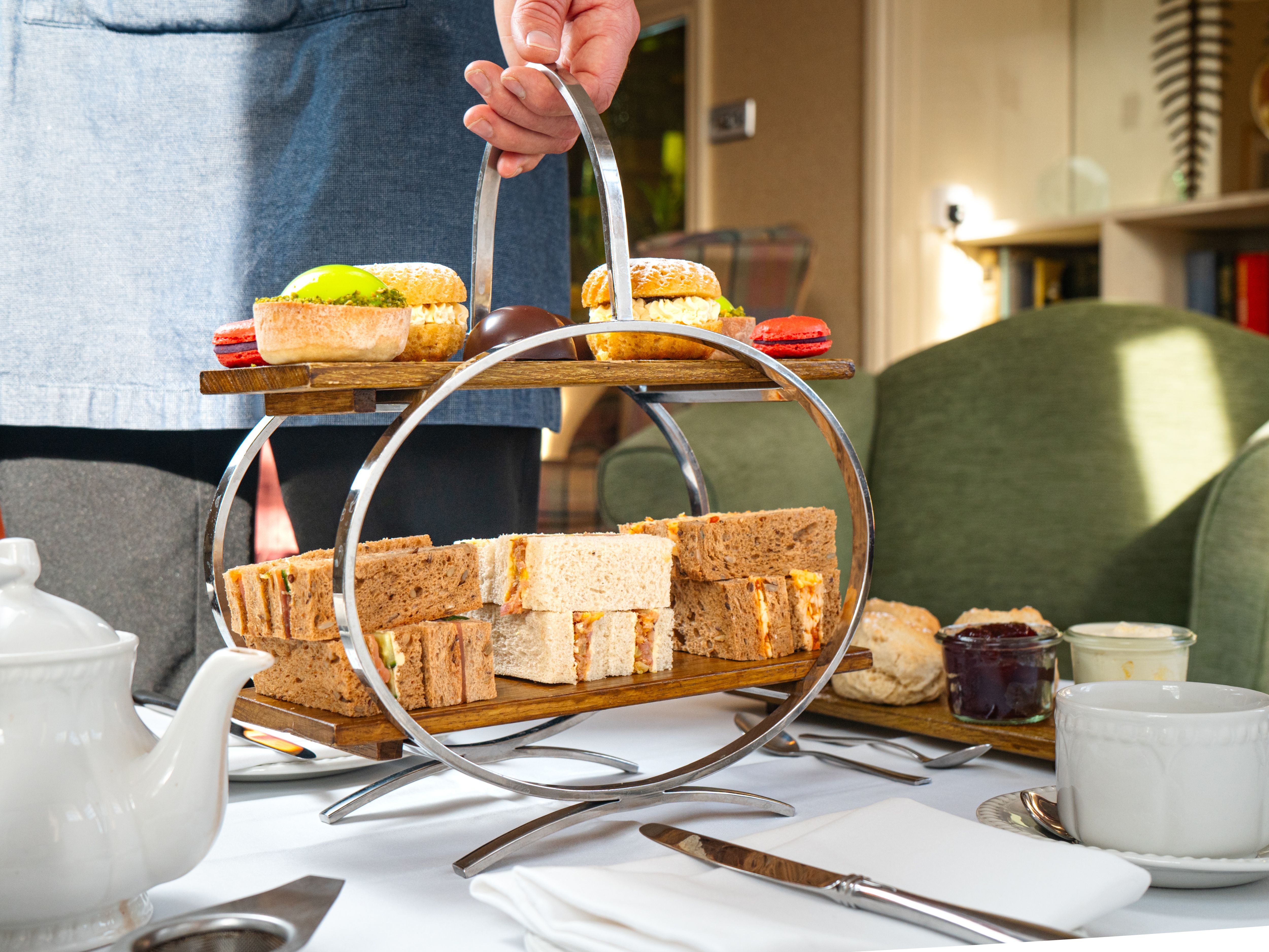 Ilsington Hotel Afternoon Tea A metal three tier cake stand full of sandwiches and sweet treats