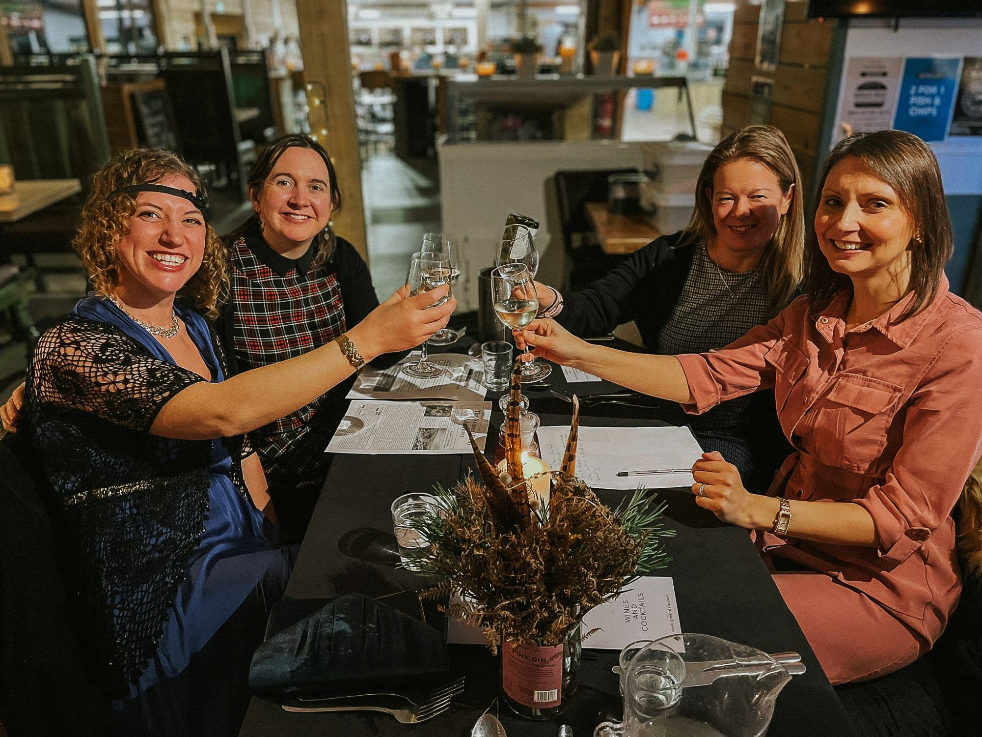 A table of four smiling women at the Greendale Farm Shop murder mystery night