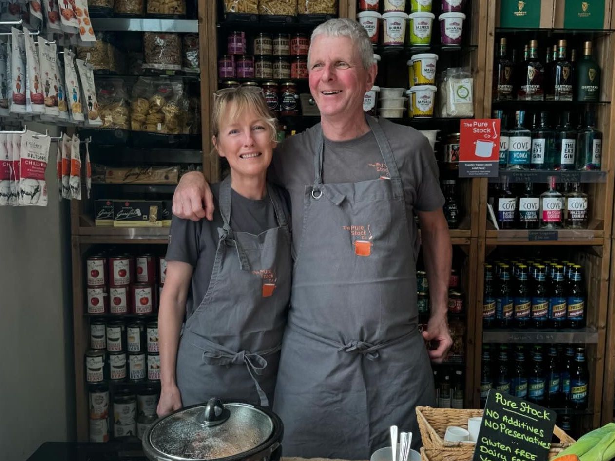 Pure Stock Co. owners standing behind a stock pot
