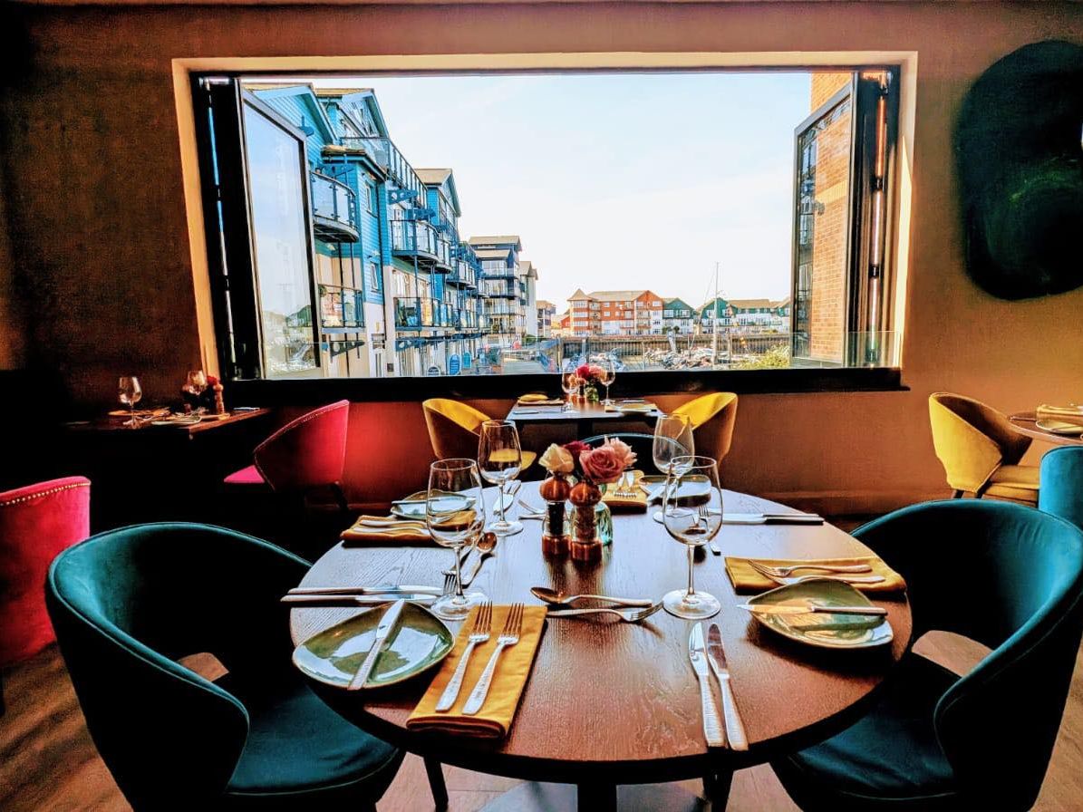 La Mar Restaurant Exmouth view over a table laid for a meal out of the window at Exmouth Marina