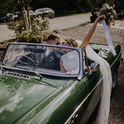 After getting married, the bride and groom are ready to set off in an open-top car.