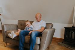 Man and child sat on sofa