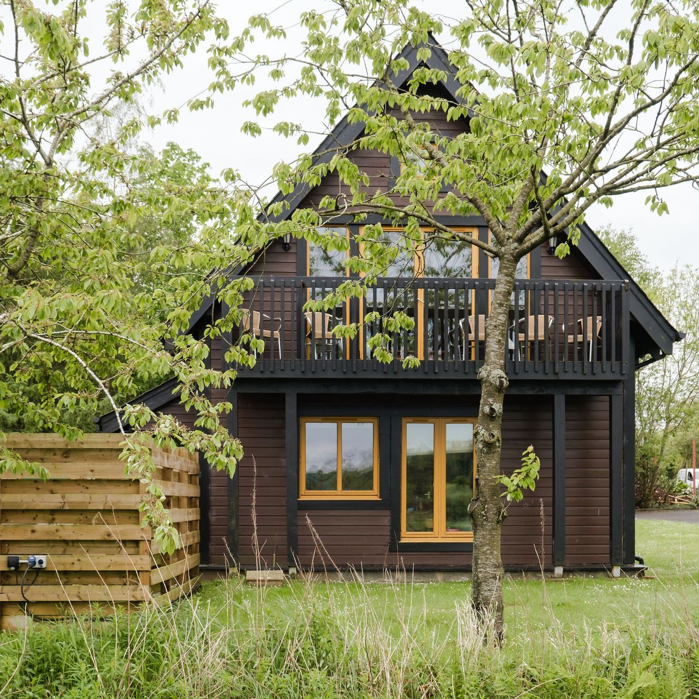 A view of our Glen Shee waterside lodge from the outside, with trees surrounding it.