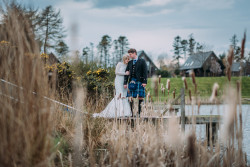 Bride and groom by fishing pond