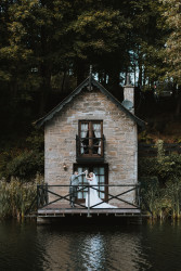 Bride and groom on boathouse balcony