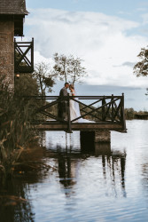 Bride and groom on boathouse balcony