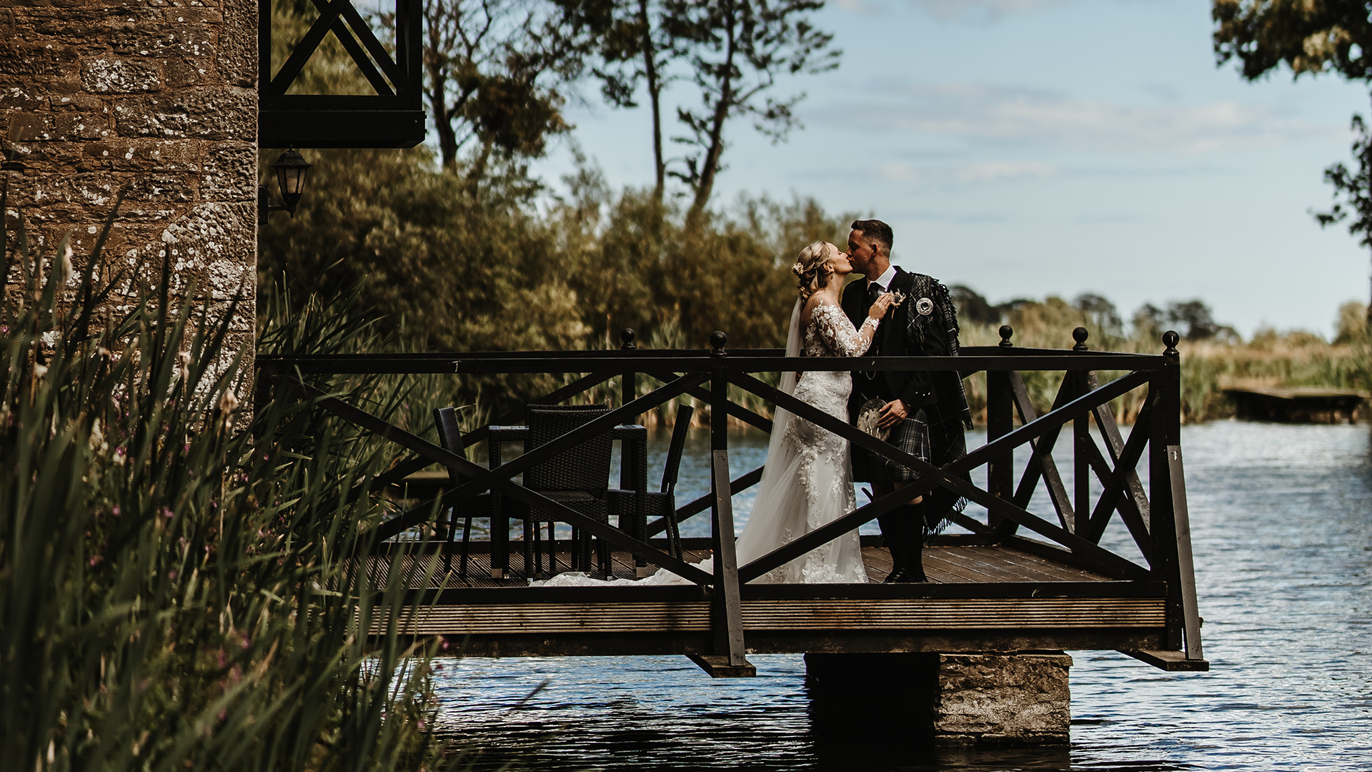Bride and groom on boathouse balcony