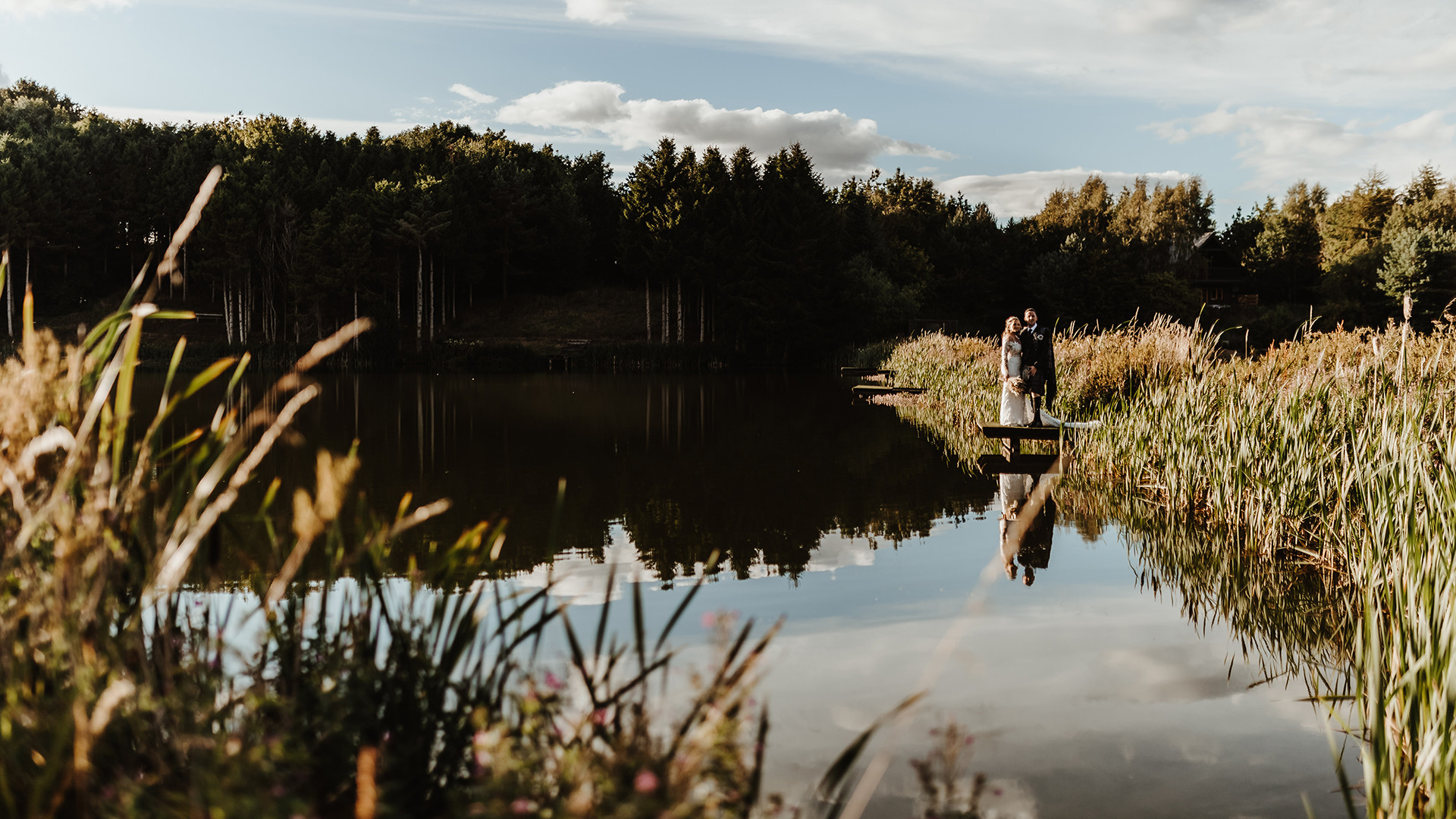 Bride and groom by fishing pond