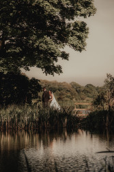 Bride and groom by fishing pond