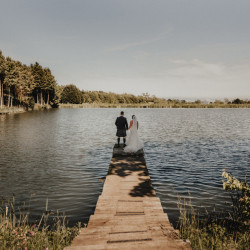 Bride and groom by fishing pond