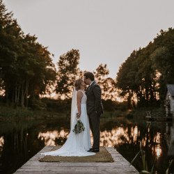 Bride and groom by fishing pond