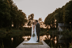 Bride and groom by fishing pond