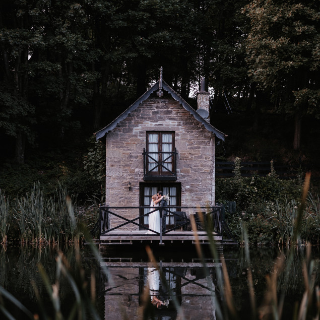 Bride and groom on boathouse balcony