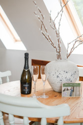 Prosecco and glasses on table with vase