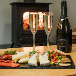 Charcuterie with Prosecco on table by fireplace