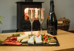 Charcuterie with Prosecco on table by fireplace