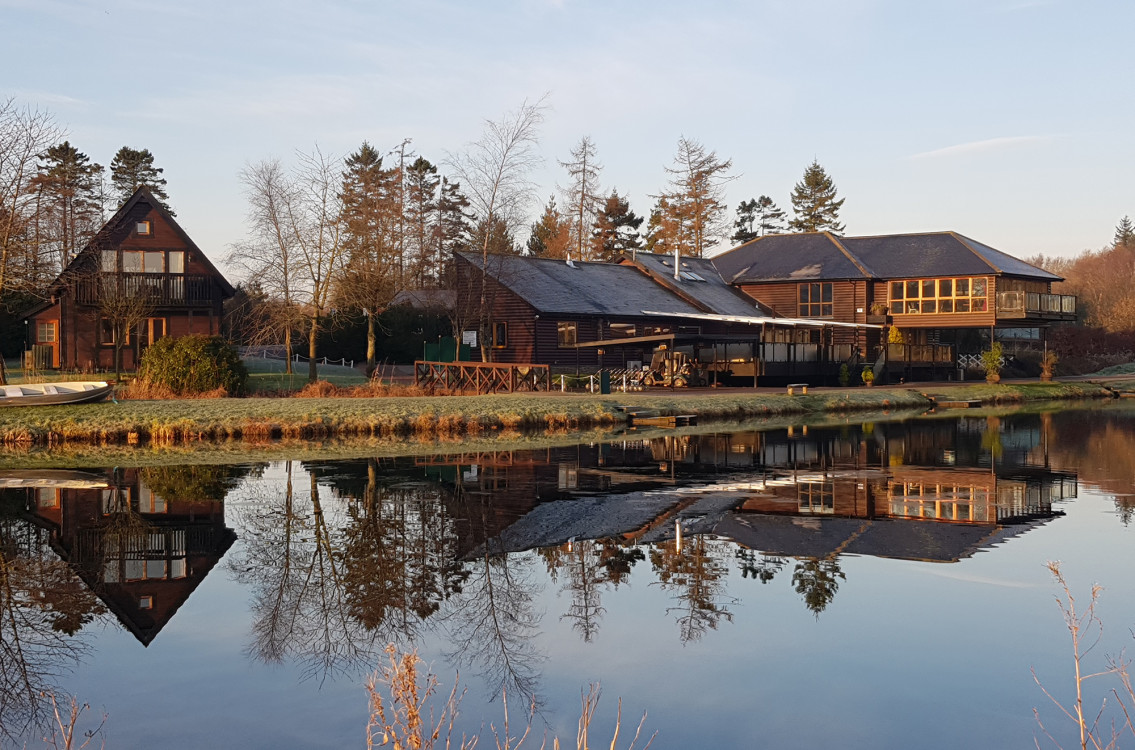 Restaurant and lodges reflection in fishing pond