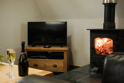 Tv and log burner with glasses of Prosecco on table